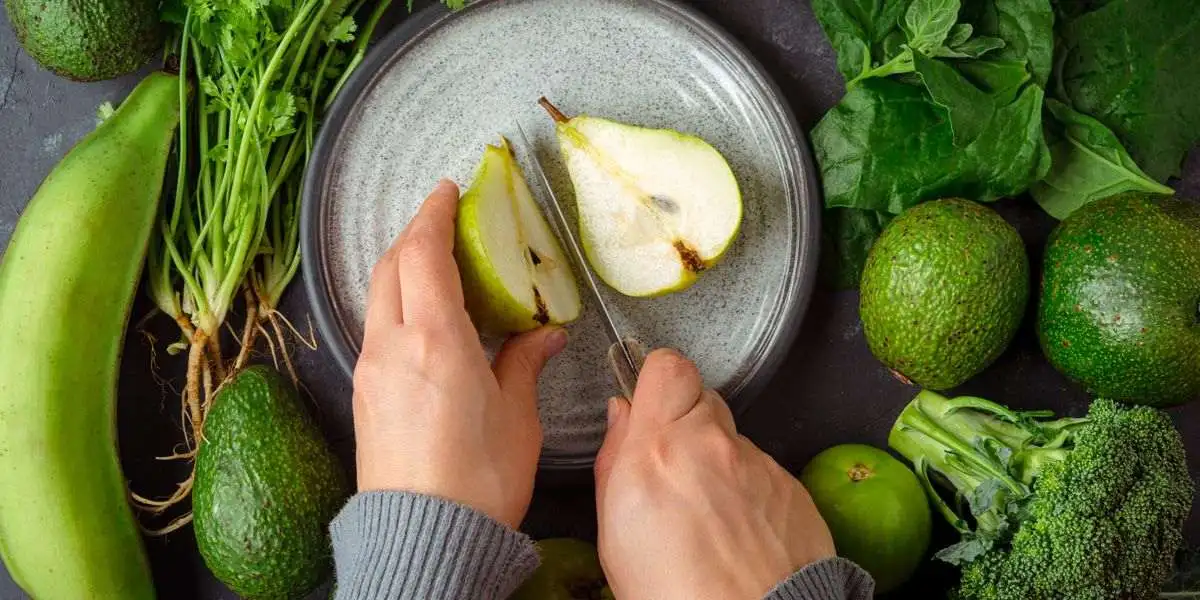 Taglio di una pera con intorno avocado, broccoli e banane Taglio di una pera con intorno avocado, broccoli e banane