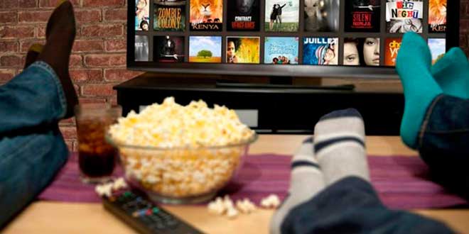 Snacks poco salutari mentre si guarda la TV Snacks poco salutari mentre si guarda la TV